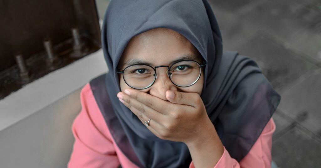Shy woman covering her mouth, learning how to stop being shy
