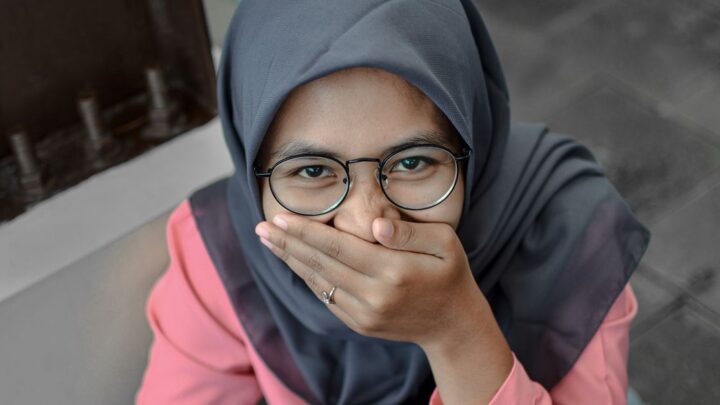 Shy woman covering her mouth, learning how to stop being shy
