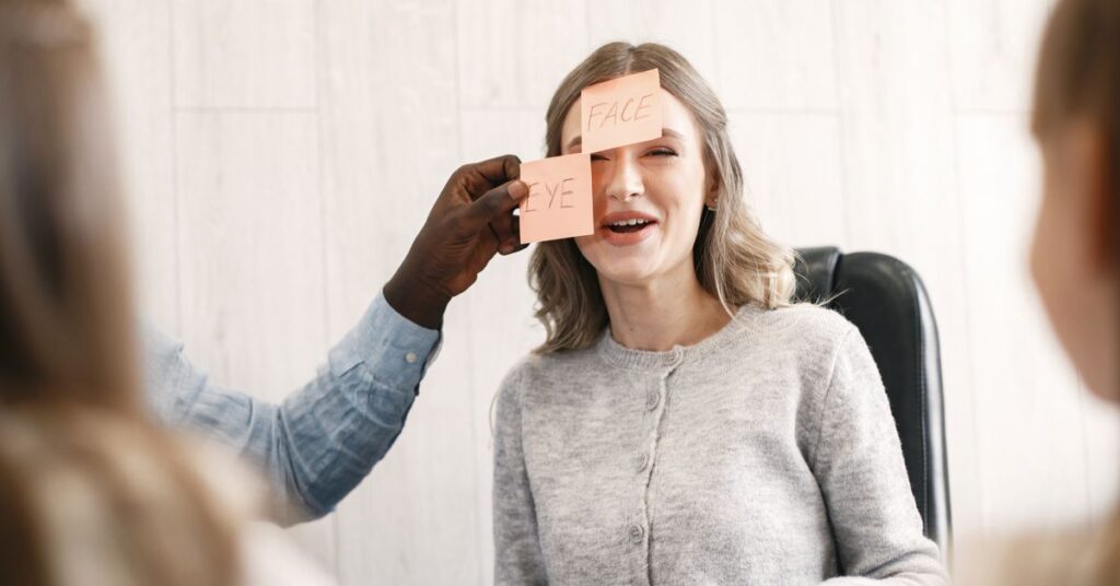 Woman laughing during a sticky note ice breakers game at work