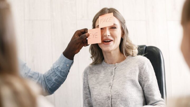 Woman laughing during a sticky note ice breakers game at work
