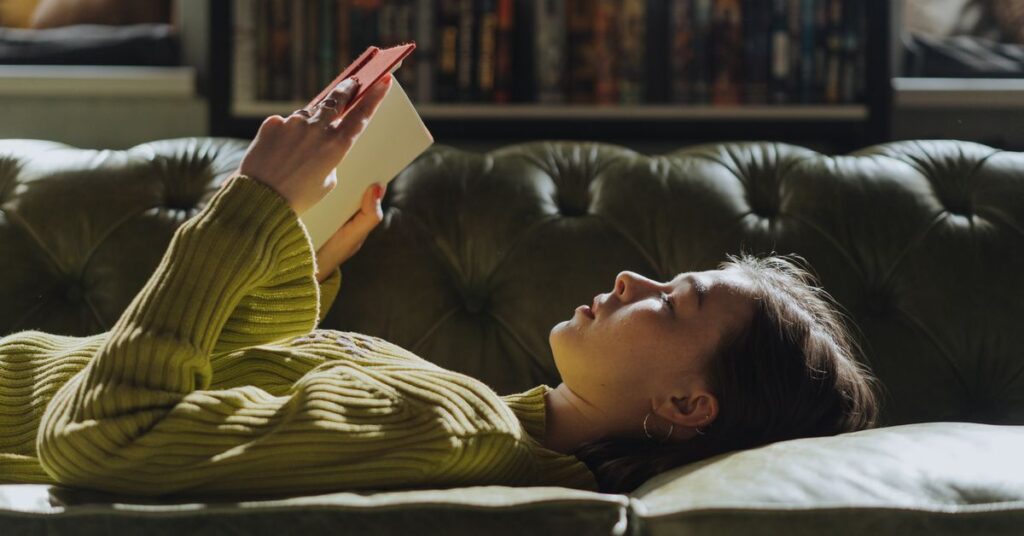 Introvert reading a book alone on a sofa, an introvert vs extrovert example